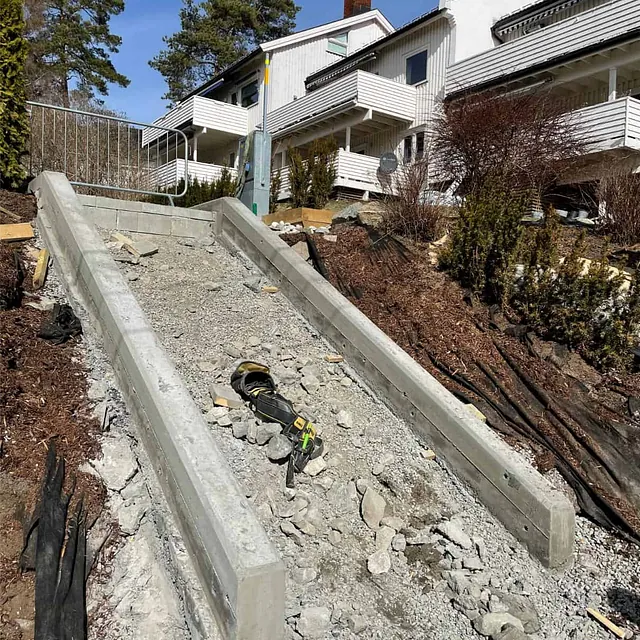 Betongvanger etablert langs trappeanlegg som grunnlag for ny adkomst mellom terrengnivåer.