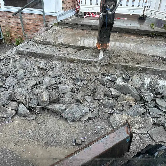 Eksisterende betongtrapp pigges opp og fjernes som del av rehabilitering av inngangspartiet.