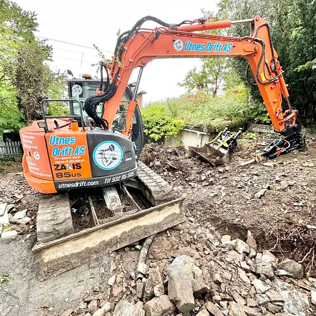 Gravemaskin fjerner sprengt berg og løsmasser under omfattende grunnarbeider på tomten.