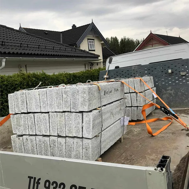 Granittkantstein transporteres på tilhenger, klar for levering og montering på prosjekt.