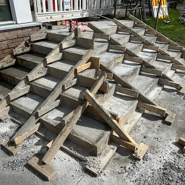 Nystøpt betongtrapp under herding med deler av forskalingen fortsatt påmontert.