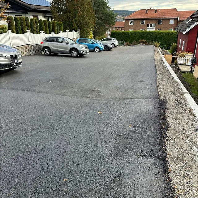 Ferdigstilt asfaltert parkeringsareal med oppmerkede kanter og god overvannsavrenning.