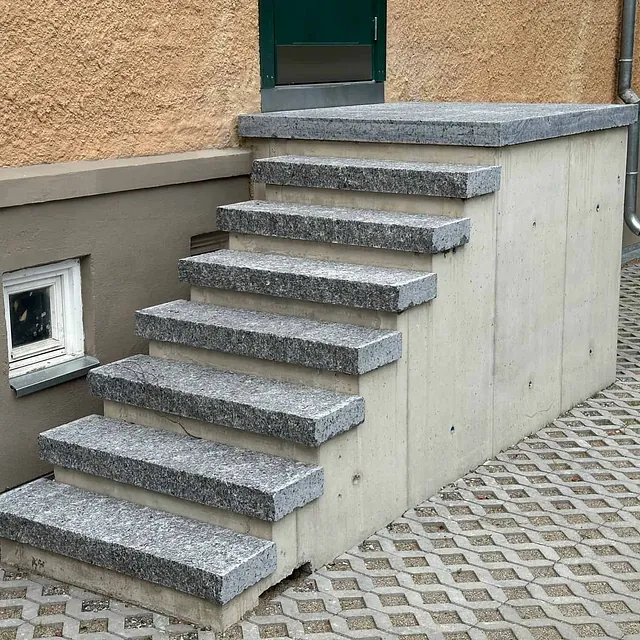 Ny betongtrapp med granittkledning og repos gir trygg adkomst til bygningens inngang.