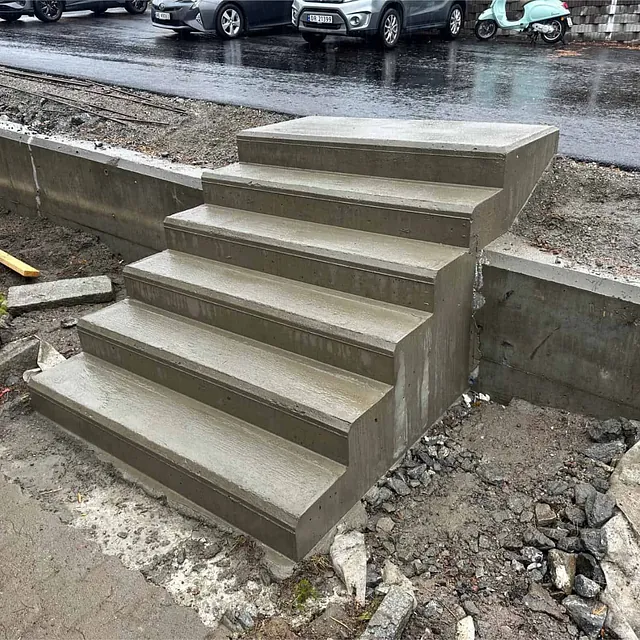 Ny støpt betongtrapp gir trygg adkomst mellom parkeringsområde og lavere terreng.