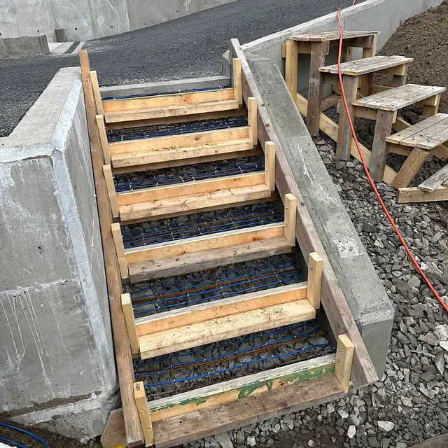 Forskaling og armering klargjøres for støping av betongtrapp ved rampe og støttemur.