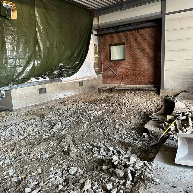 Utgravd og oppfylt område med pukk klargjort for etablering av ny betongkonstruksjon.