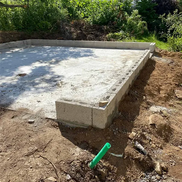 Ferdigstøpt betongplate med ringmur klar for videre oppføring av ny konstruksjon.