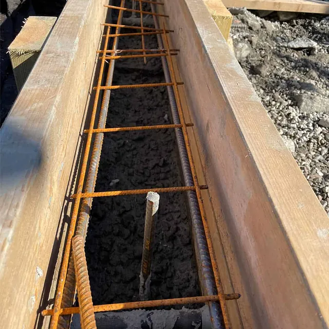 Nærbilde av armeringsjern montert i forskaling før støping av betongvange til trappeanlegg.