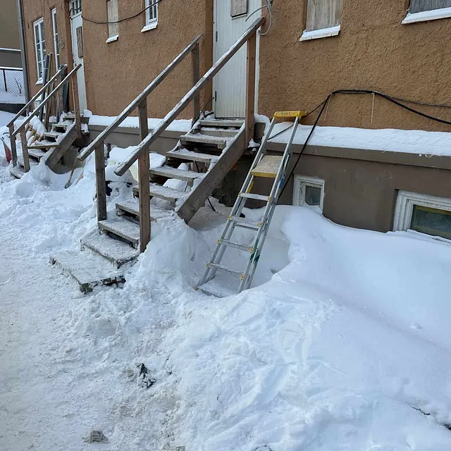 Midlertidige tretrapper gir adkomst til innganger i snødekt område under byggearbeid.