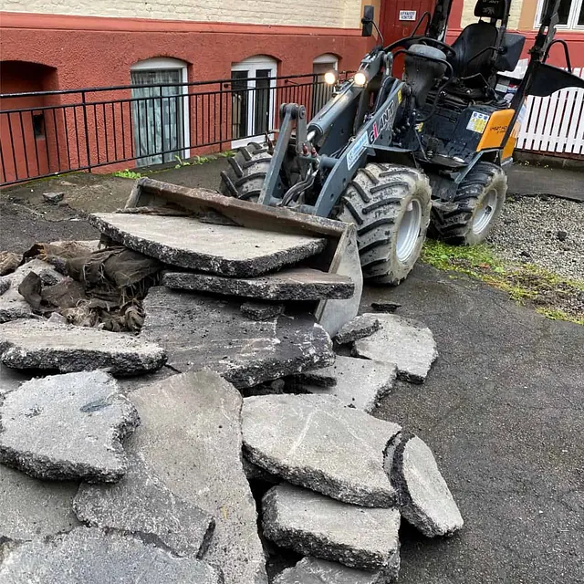 Oppbrutt asfalt og betong lastes bort med hjullaster under ombygging av uteområdet.