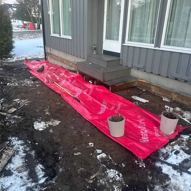Område ved terrasse og inngang sikres med duk under pågående dreneringsarbeid.