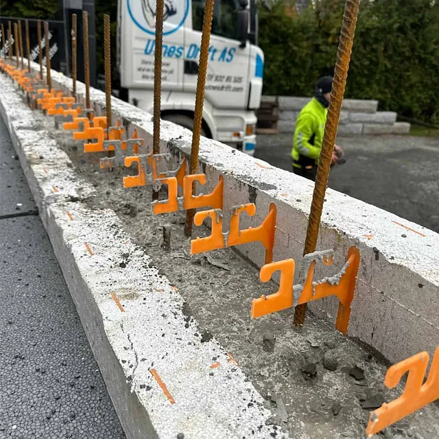 Armeringsjern med avstandsholdere montert i forskalingsblokker før støping av vegger.