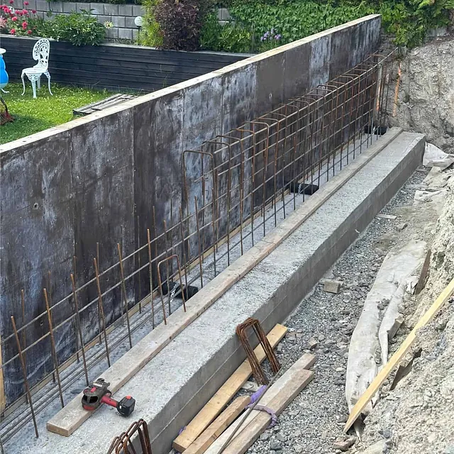 Armering og forskaling montert på betongsåle før støping av ny støttemur.