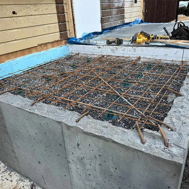 Armeringsnett montert i fundament før støping av betongdekke til nytt tilbygg.