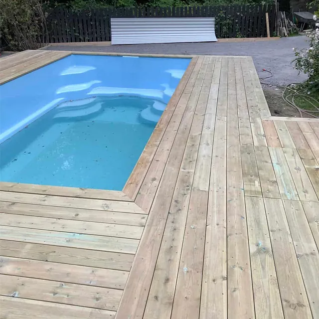 Ferdigstilt terrasse med integrert basseng og sammenhengende dekke i trykkimpregnert tre.