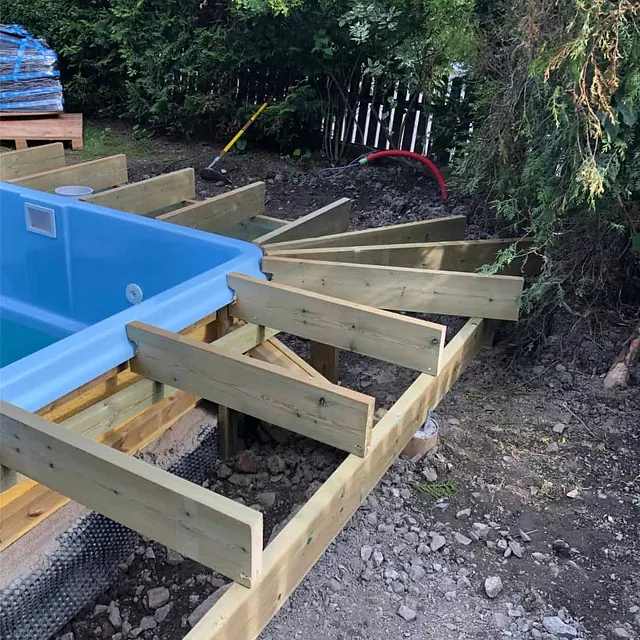 Terrassebjelker monteres rundt basseng som grunnlag for fremtidig terrassekonstruksjon.
