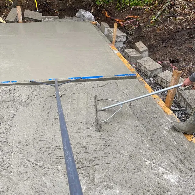 Betongplate avrettes og glattes under støpearbeid for nytt fundament eller byggverk.