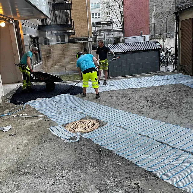 Varmekabler legges før asfaltering av gårdsplass for snø- og isfri adkomst.